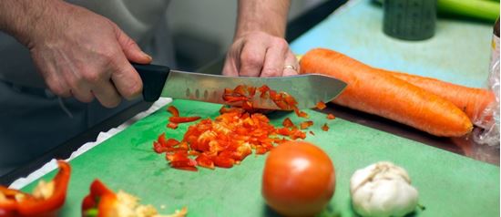 Hands slicing peppers