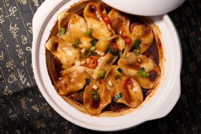 Dumplings in a white baking dish with sauce