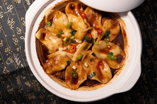 Dumplings in a white baking dish with sauce